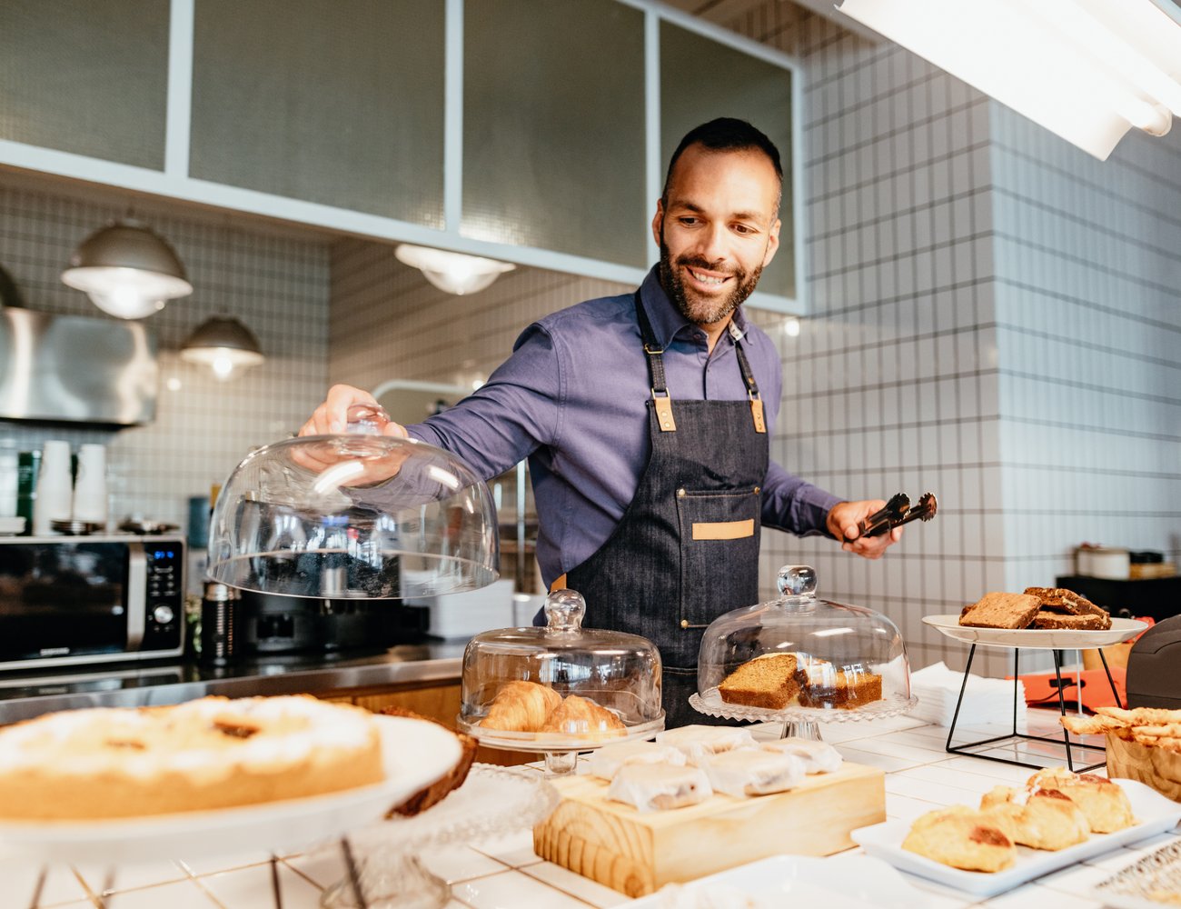 A small business owner arranging his bakery counter